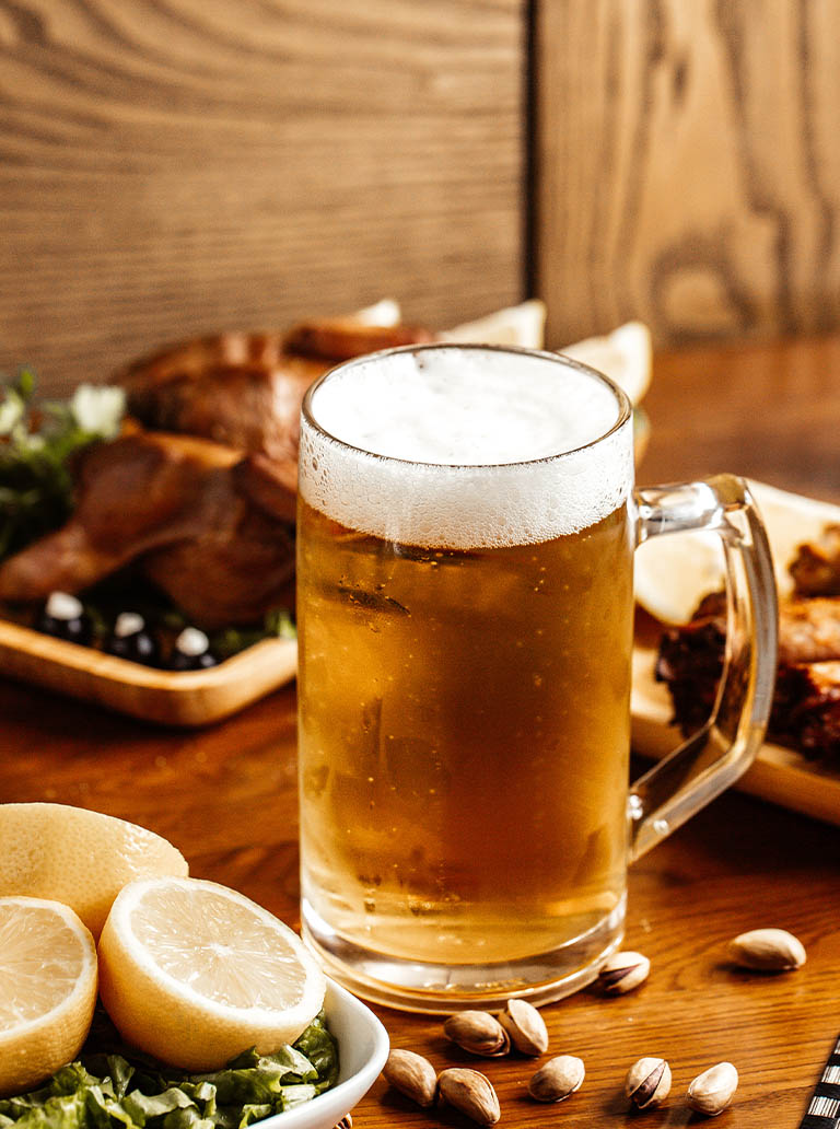 conveniencia_0000_front-view-fried-meat-with-beer-lemon-nuts-brown-wooden-desk-snack-nut-food-meal