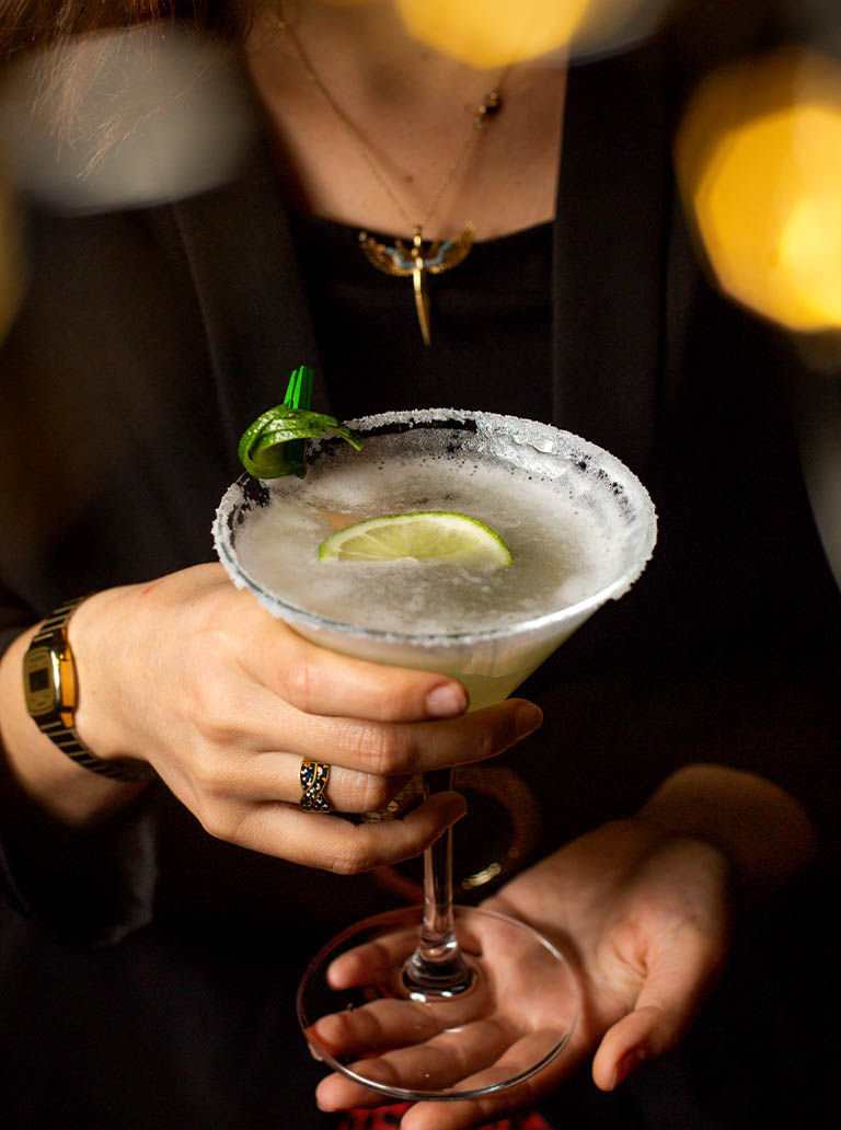 drink_0001_woman-holding-margarita-glass-garnished-with-lime